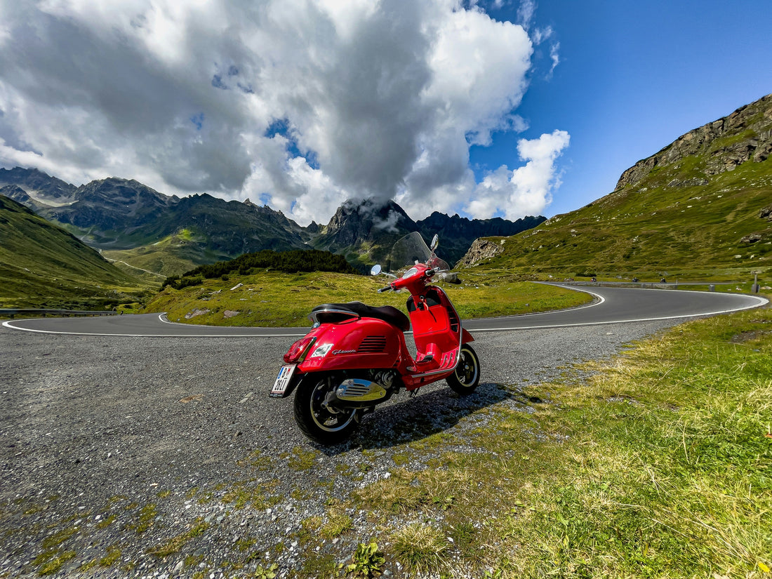 Rote Vespa GTS auf einer kurvigen Bergstraße als Motiv für den Vergleich zwischen GTS 125 und GTS 300 beziehungsweise 310