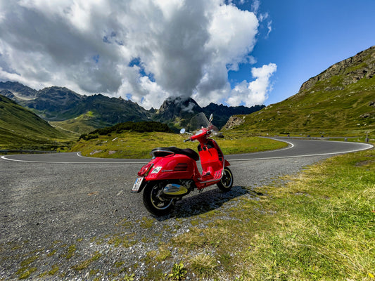 Rote Vespa GTS auf einer kurvigen Bergstraße als Motiv für den Vergleich zwischen GTS 125 und GTS 300 beziehungsweise 310