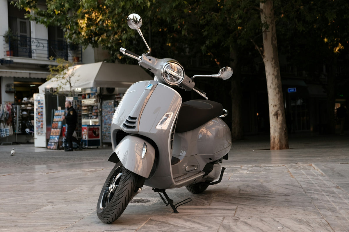 Graue moderne Vespa im urbanen Umfeld